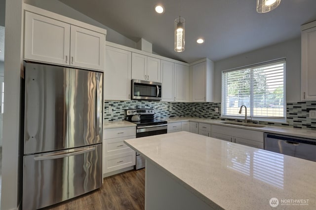 2201 303rd Pl, Ocean Park, WA 98640 - kitchen featuring stainless steel appliances, a sink, vaulted ceiling, tasteful backsplash, and white cabinetry