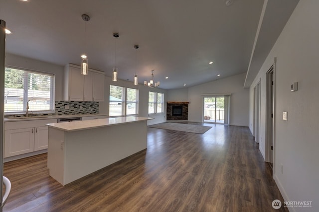 2201 303rd Pl, Ocean Park, WA 98640 - kitchen with a sink, dark wood-type flooring, a kitchen island, white cabinetry, and vaulted ceiling