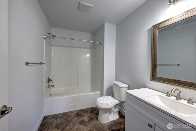 2201 303rd Pl, Ocean Park, WA 98640 - bathroom with toilet, stone tile flooring, vanity, baseboards, and bathtub / shower combination