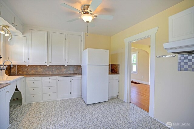 27120 36th Ave NW, Stanwood, WA 98292 - kitchen with freestanding refrigerator, white cabinets, a ceiling fan, and tasteful backsplash