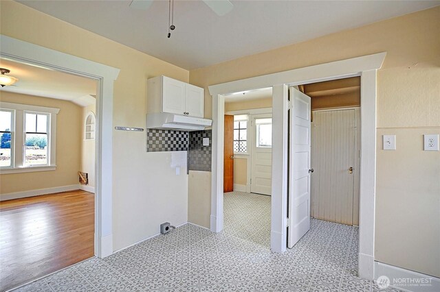27120 36th Ave NW, Stanwood, WA 98292 - kitchen featuring white cabinets, light flooring, ceiling fan, and baseboards