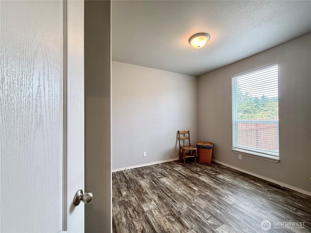 642 Weatherwax Loop NE, Ocean Shores, WA 98569 - unfurnished room featuring dark wood-style floors, baseboards, and a textured ceiling