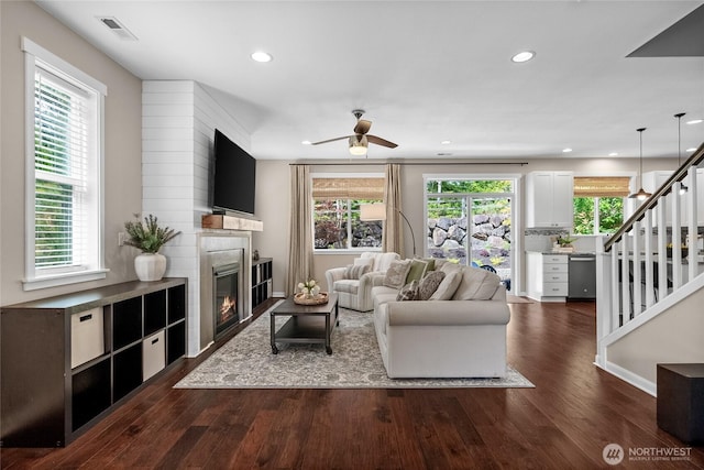 11226 Borgen Loop, Gig Harbor, WA 98332 - living room featuring a glass covered fireplace, dark wood finished floors, a ceiling fan, stairs, and recessed lighting