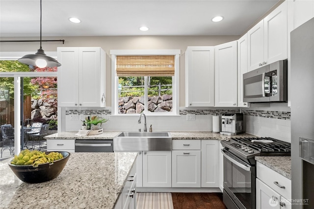 11226 Borgen Loop, Gig Harbor, WA 98332 - kitchen featuring appliances with stainless steel finishes, plenty of natural light, white cabinetry, decorative backsplash, and recessed lighting