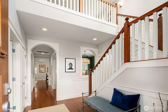 5102 S Frontenac St, Seattle, WA 98118 - foyer with wood finished floors, arched walkways, stairway, a wainscoted wall, and recessed lighting