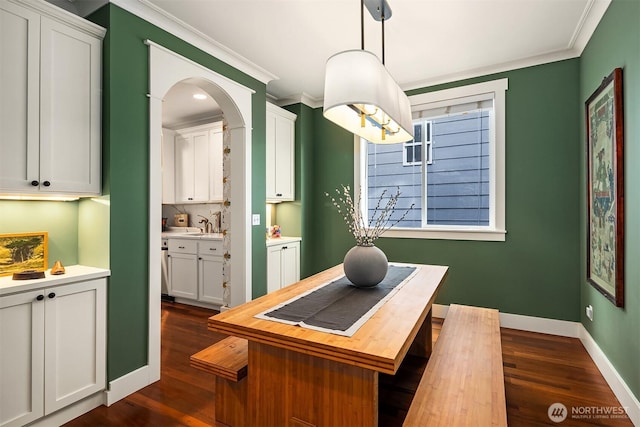 5102 S Frontenac St, Seattle, WA 98118 - home office featuring crown molding, dark wood-type flooring, baseboards, and arched walkways