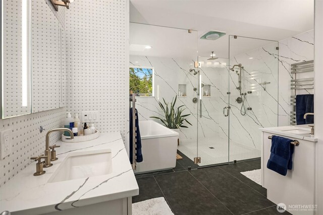 5102 S Frontenac St, Seattle, WA 98118 - bathroom with tile patterned floors, a marble finish shower, double vanity, a freestanding bath, and tile walls