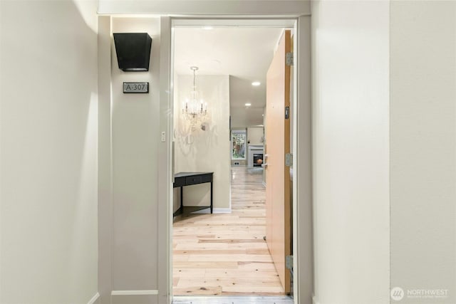 225 4th Ave Unit A307, Kirkland, WA 98033 - hallway featuring light wood finished floors, baseboards, a chandelier, and recessed lighting