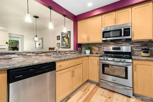 225 4th Ave Unit A307, Kirkland, WA 98033 - kitchen featuring appliances with stainless steel finishes, a sink, light brown cabinets, a peninsula, and light wood-style floors