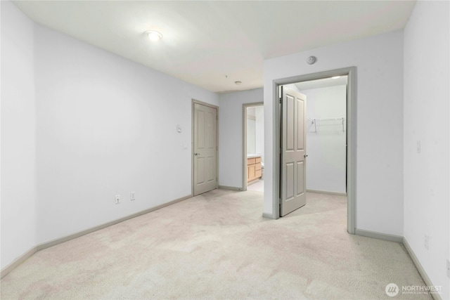 225 4th Ave Unit A307, Kirkland, WA 98033 - unfurnished bedroom with light carpet, a walk in closet, baseboards, a closet, and ensuite bathroom