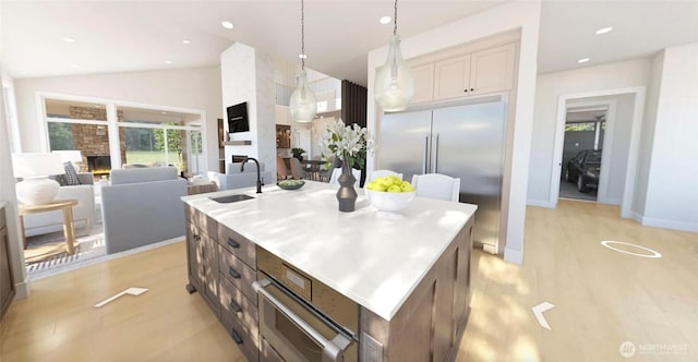 12925 NE 70th Ln, Kirkland, WA 98033 - kitchen with a sink, a center island with sink, light wood-type flooring, vaulted ceiling, and decorative light fixtures