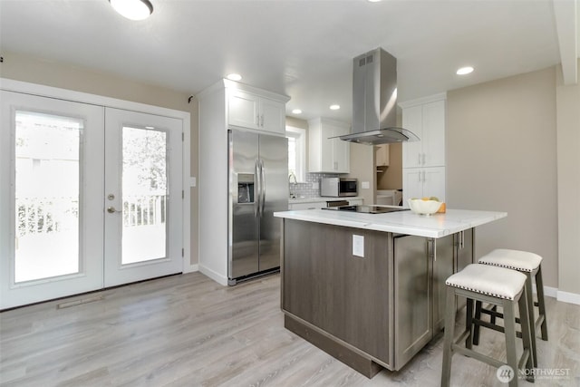 17801 111th Ave SE, Renton, WA 98055 - kitchen featuring stainless steel appliances, island range hood, french doors, white cabinetry, and a breakfast bar area