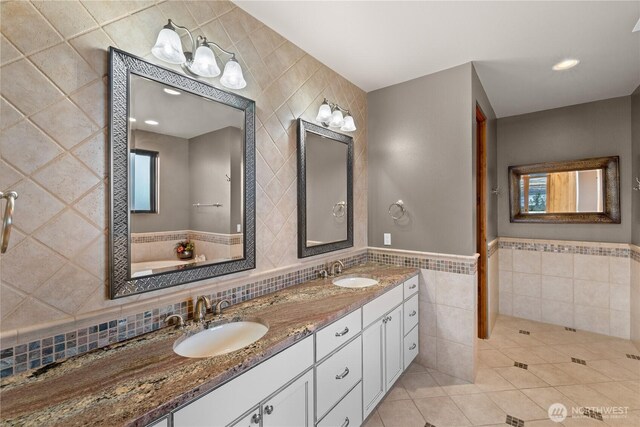 510 Lakeside Way SW, Mattawa, WA 99349 - full bathroom with tile walls, double vanity, tile patterned flooring, a bath, and a wainscoted wall