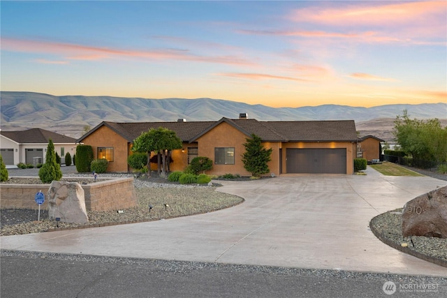 510 Lakeside Way SW, Mattawa, WA 99349 - ranch-style home with a mountain view, curved driveway, a garage, stucco siding, and a chimney