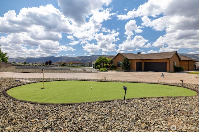 510 Lakeside Way SW, Mattawa, WA 99349 - view of home's community with an area to practice putting, curved driveway, a mountain view, and a garage