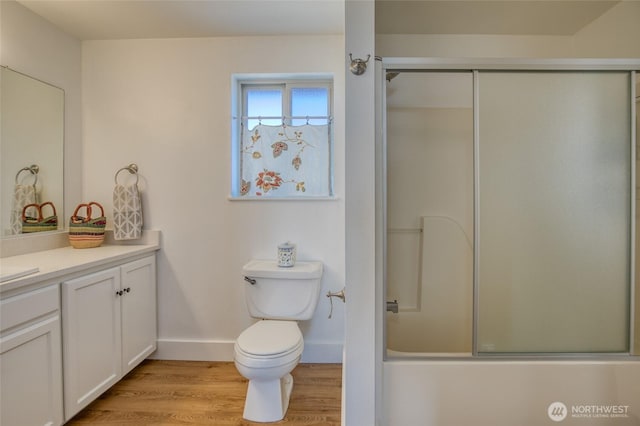 1472 Storm King Ave SW Unit A, Ocean Shores, WA 98569 - bathroom with vanity, baseboards, toilet, wood finished floors, and combined bath / shower with glass door