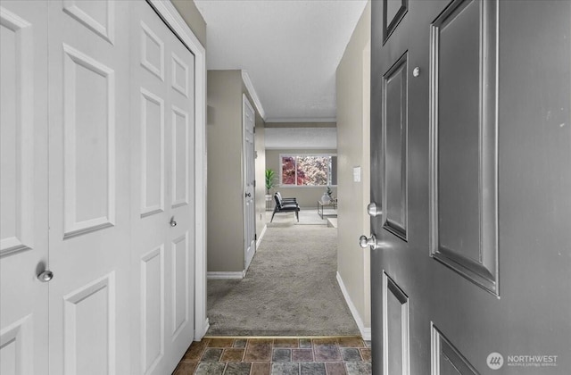 13013 E Gibson Rd Unit M223, Everett, WA 98204 - hallway featuring baseboards, dark colored carpet, dark stone finish flooring, and crown molding