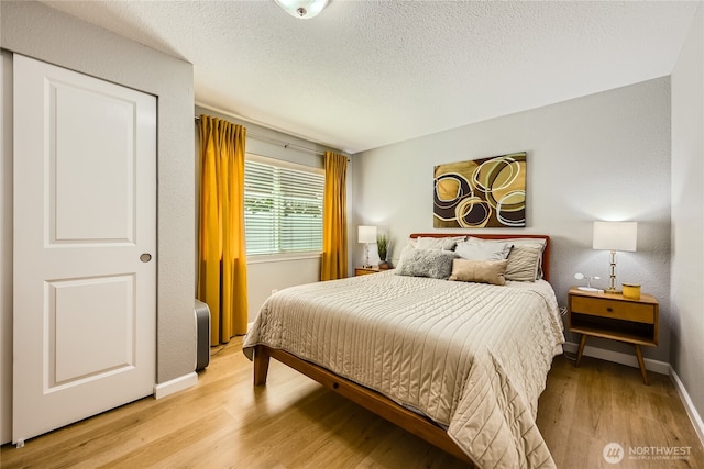 3045 20th Ave W Unit 108, Seattle, WA 98199 - bedroom featuring light wood-style flooring, baseboards, and a textured ceiling