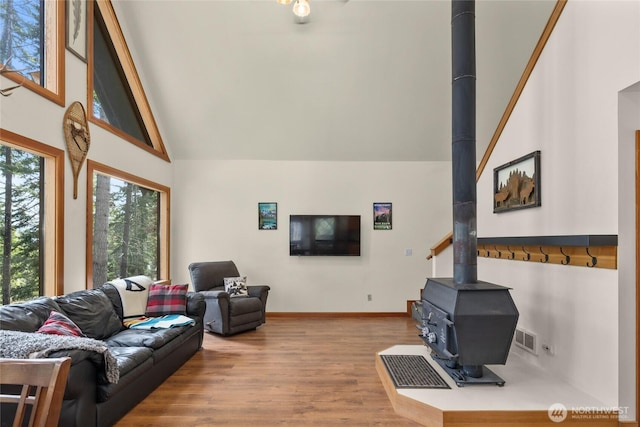 760 Rodeo Rd, Cle Elum, WA 98922 - living room featuring high vaulted ceiling, a wood stove, wood finished floors, and baseboards