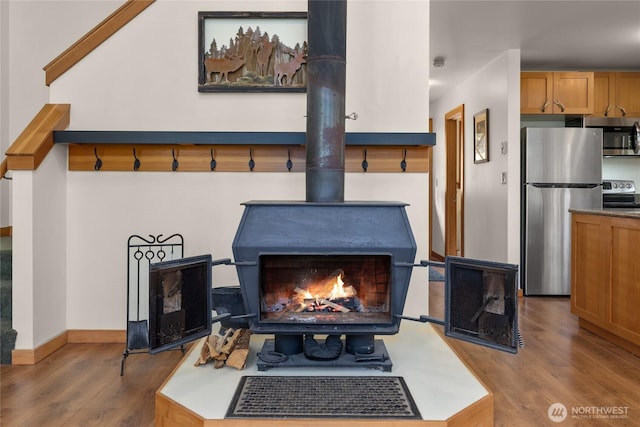 760 Rodeo Rd, Cle Elum, WA 98922 - detailed view of appliances with stainless steel finishes, a wood stove, wood finished floors, and baseboards