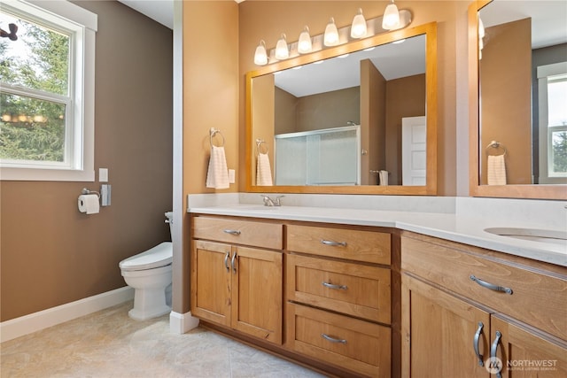 15 Cabana Dr, Silverlake, WA 98645 - full bathroom with double vanity, baseboards, toilet, and a stall shower