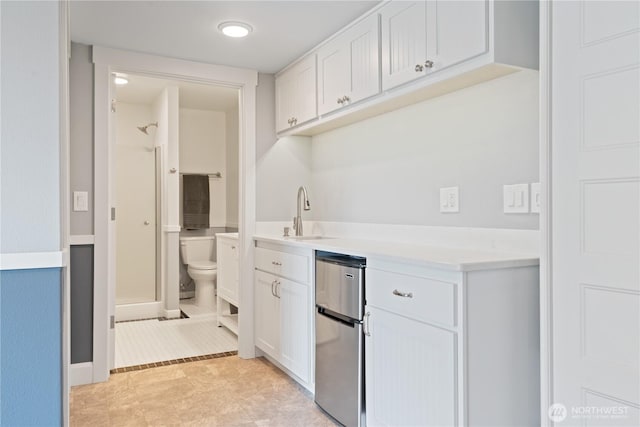 15 Cabana Dr, Silverlake, WA 98645 - kitchen with refrigerator, a sink, white cabinetry, light countertops, and baseboards