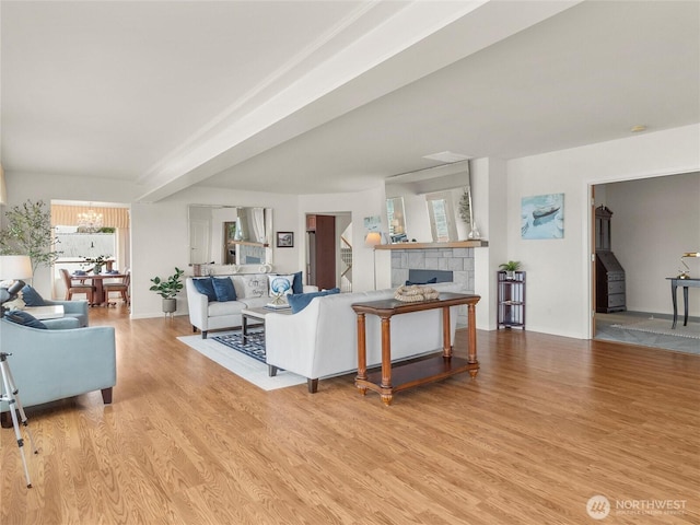 8609 E Caraway Rd, Port Orchard, WA 98366 - living area featuring light wood-style flooring, a fireplace, a chandelier, and baseboards