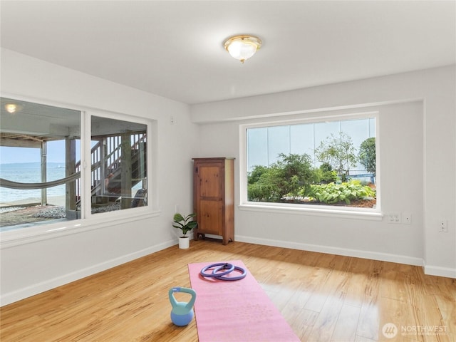 8609 E Caraway Rd, Port Orchard, WA 98366 - workout area with wood finished floors, baseboards, and a water view