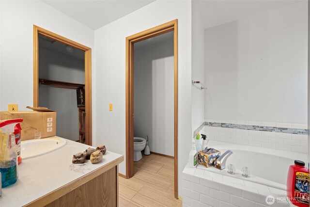 26603 199th Pl SE, Covington, WA 98042 - bathroom with toilet, a garden tub, vanity, and baseboards