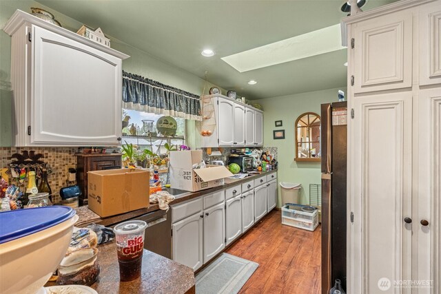 26603 199th Pl SE, Covington, WA 98042 - kitchen with a skylight, freestanding refrigerator, decorative backsplash, light wood-style floors, and recessed lighting