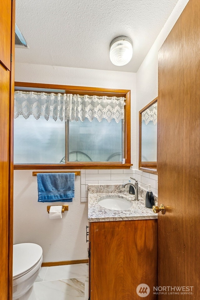 38205 183rd Ave SE, Auburn, WA 98092 - half bathroom with baseboards, toilet, vanity, and a textured ceiling