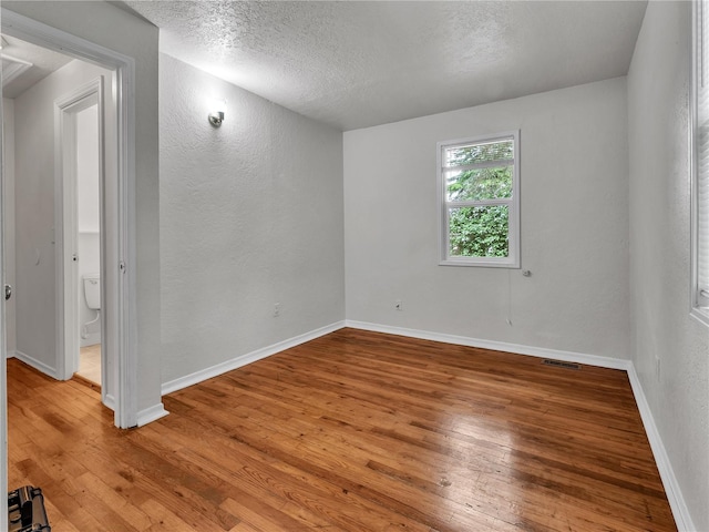 14746 26th Ave NE, Shoreline, WA 98155 - empty room featuring wood-type flooring, a textured ceiling, a textured wall, and baseboards