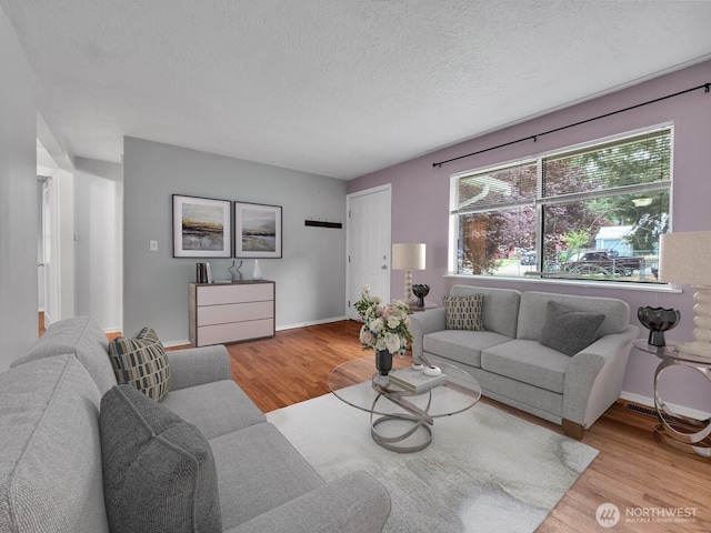 14746 26th Ave NE, Shoreline, WA 98155 - living area featuring wood finished floors, a textured ceiling, and baseboards