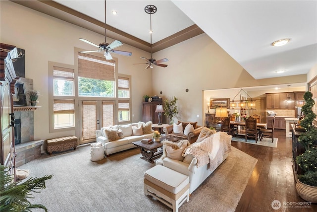 29122 71st Ave E, Graham, WA 98338 - living room with a fireplace with raised hearth, a towering ceiling, dark wood finished floors, a ceiling fan, and a chandelier