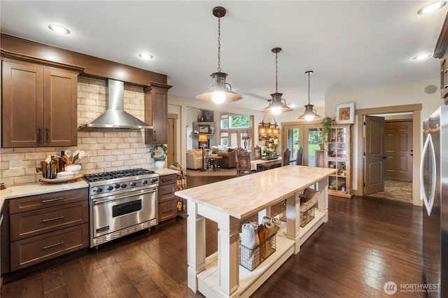 29122 71st Ave E, Graham, WA 98338 - kitchen featuring stainless steel appliances, wall chimney exhaust hood, dark wood-style floors, decorative backsplash, and pendant lighting