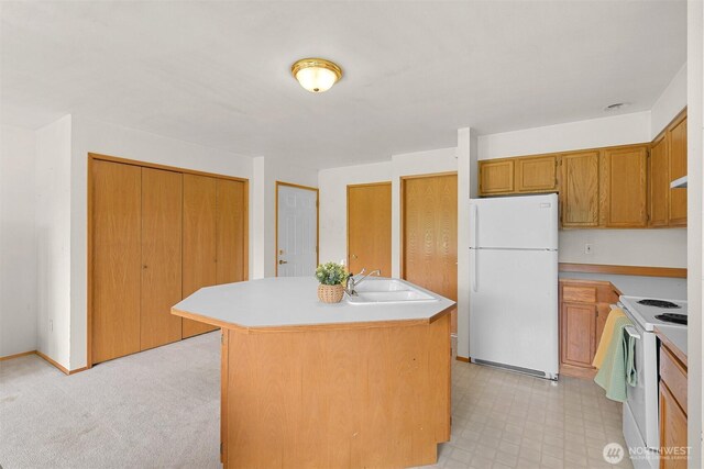 262 W Maberry Dr Unit 102, Lynden, WA 98264 - kitchen featuring white appliances, a sink, light countertops, an island with sink, and brown cabinets