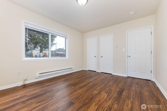 811 E 60th St, Tacoma, WA 98404 - unfurnished bedroom with baseboard heating, dark wood-style floors, and baseboards