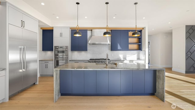 17109 NE 16th Pl, Bellevue, WA 98008 - kitchen with wall chimney exhaust hood, stainless steel appliances, light wood-style flooring, a sink, and recessed lighting