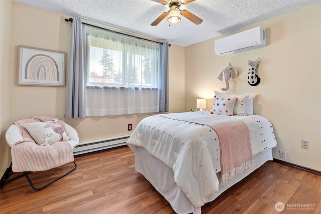 17009 15th Ave E, Spanaway, WA 98387 - bedroom featuring an AC wall unit, a baseboard heating unit, a textured ceiling, wood finished floors, and ceiling fan