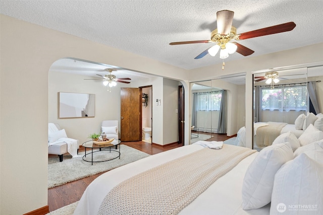 17009 15th Ave E, Spanaway, WA 98387 - bedroom featuring arched walkways, a textured ceiling, wood finished floors, and a ceiling fan