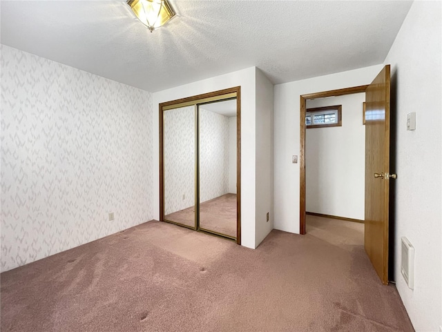 2147 Beverly Blvd, Shelton, WA 98584 - unfurnished bedroom with carpet flooring, wallpapered walls, a closet, and a textured ceiling