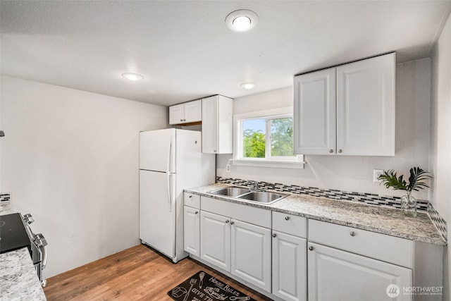 2042 E Harrison St, Tacoma, WA 98404 - kitchen featuring freestanding refrigerator, a sink, white cabinetry, and stainless steel range with electric stovetop
