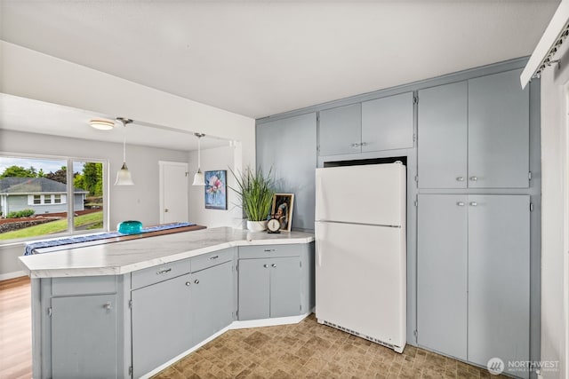 2042 E Harrison St, Tacoma, WA 98404 - kitchen featuring freestanding refrigerator, gray cabinets, a peninsula, and light countertops