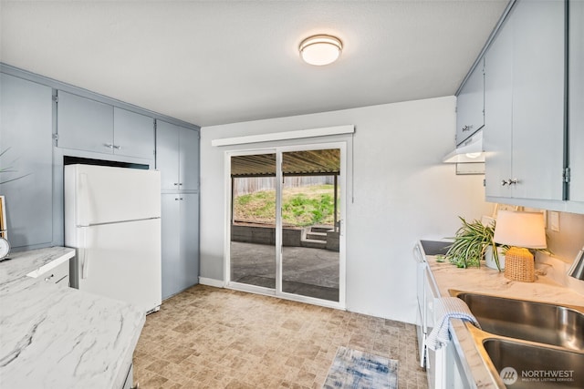 2042 E Harrison St, Tacoma, WA 98404 - kitchen featuring freestanding refrigerator, a sink, light stone counters, range hood, and gray cabinetry