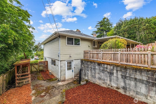 2042 E Harrison St, Tacoma, WA 98404 - rear view of house with a fenced backyard, a chimney, and a shingled roof