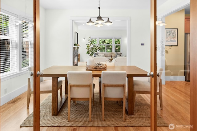 9385 NE N Town Loop, Bainbridge Island, WA 98110 - dining space featuring wood finished floors, baseboards, french doors, and a chandelier