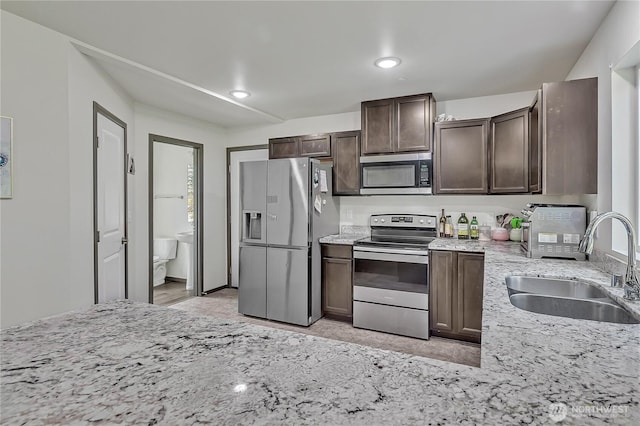 13218 197th St E, Graham, WA 98338 - kitchen with stainless steel appliances, a sink, dark brown cabinetry, light stone countertops, and recessed lighting