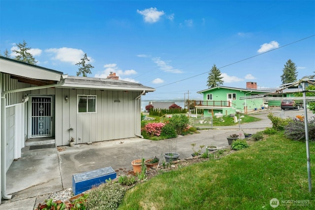 1240 Beach Dr, Camano Island, WA 98282 - view of side of property featuring board and batten siding, a chimney, and a lawn
