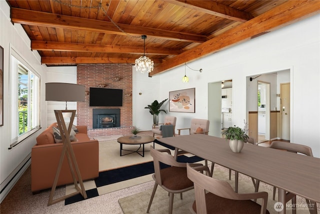 1240 Beach Dr, Camano Island, WA 98282 - dining room featuring wood ceiling with exposed beams, a baseboard heating unit, a chandelier, carpet, and a brick fireplace