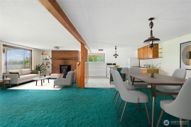 1240 Beach Dr, Camano Island, WA 98282 - dining room with a textured ceiling, a brick fireplace, light carpet, and beamed ceiling